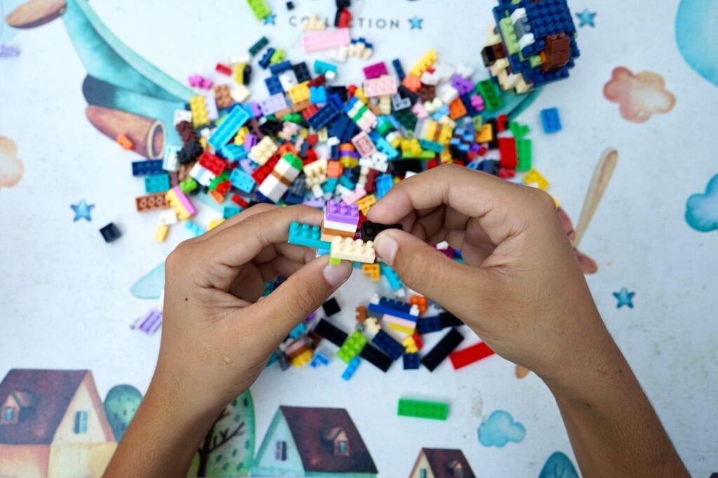 Hands assembling colorful plastic blocks on a table, sparking creativity in play.